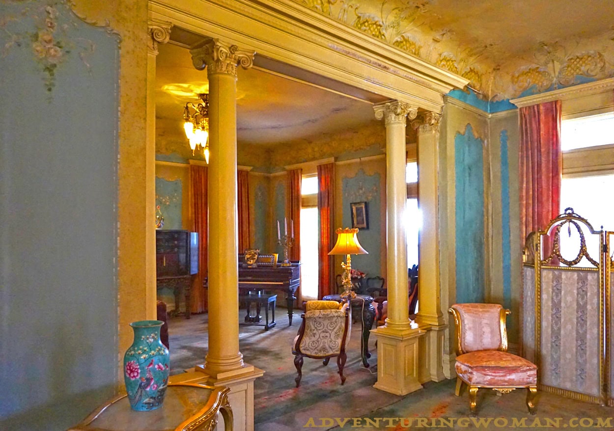 The Overholser mansion's music room seen through a passthrough from the front parlor. A grand piano and.a phonograph