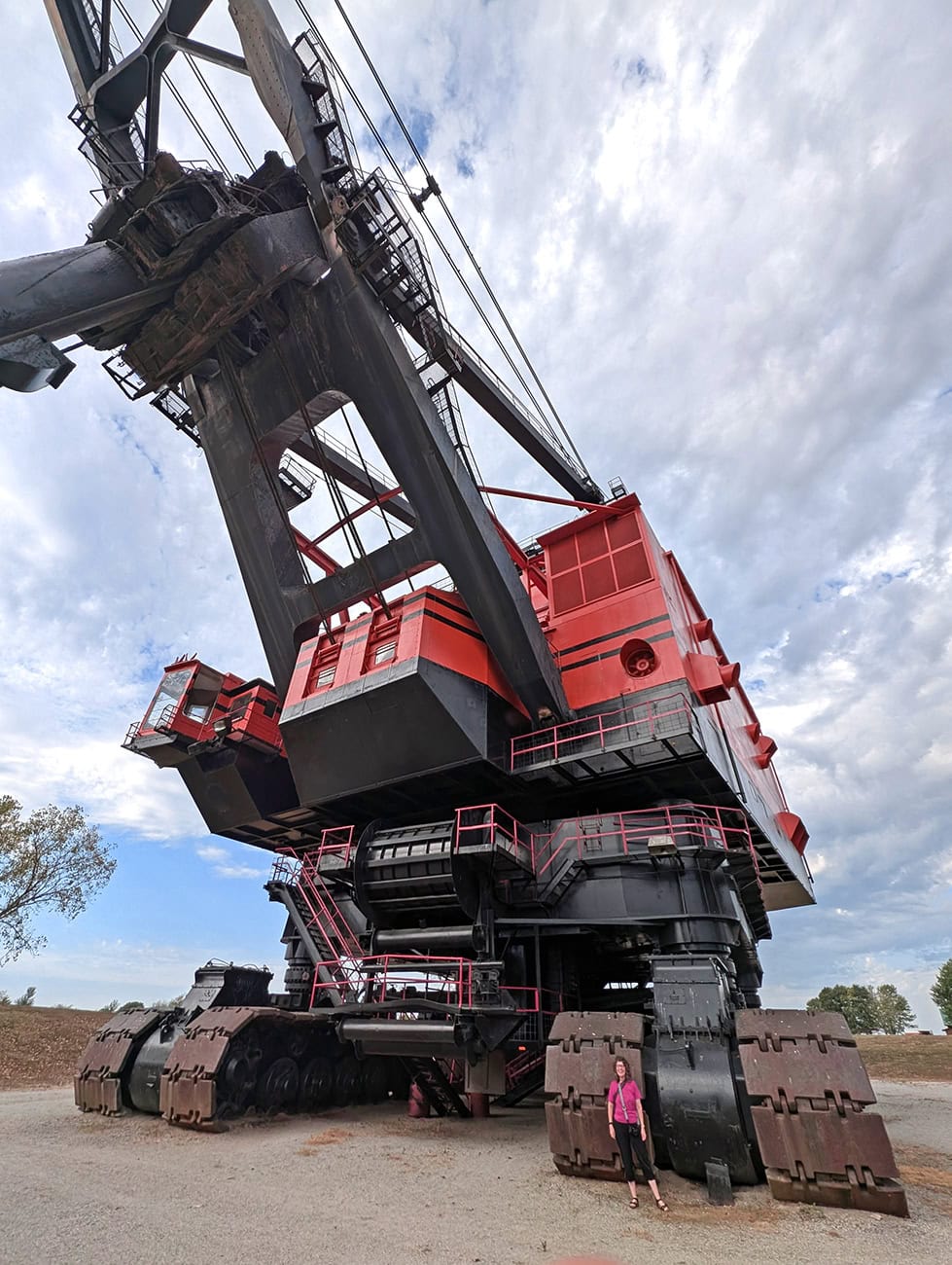 Me, Adventuring Woman with Big Brutus, a giant mining machine that's now a tourist attraction in Southeast Kansas. I am about 1/3 the size of one of the tires.